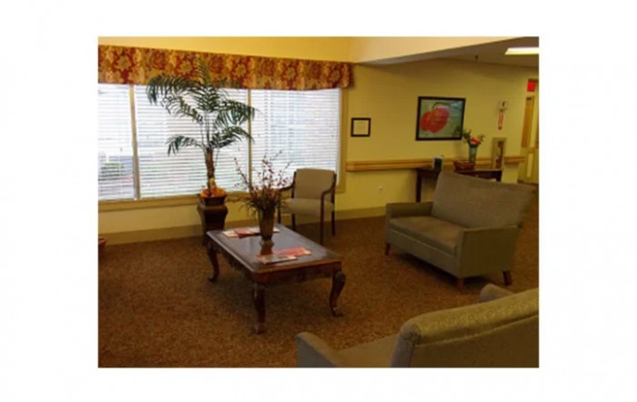 A cozy living room with a sofa, chairs, and a coffee table adorned with decorative items.
