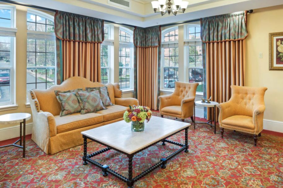 A cozy living room with elegant furniture and large windows.