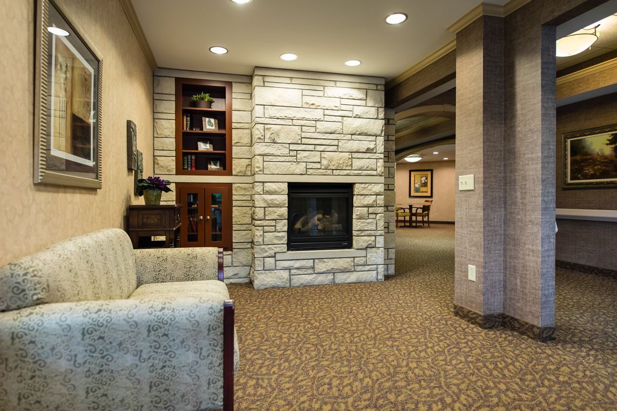 A cozy lounge area featuring a stone fireplace and comfortable seating.