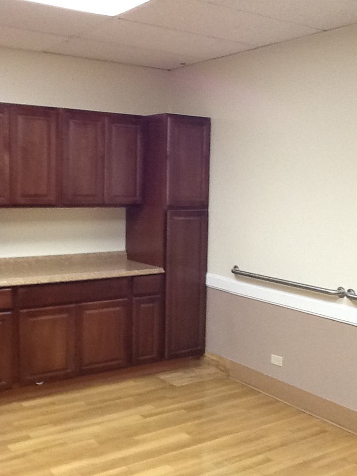 An empty room with wooden cabinets and a countertop.