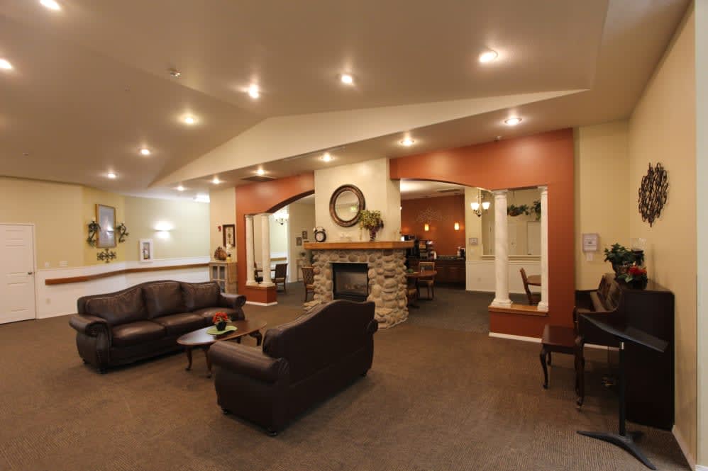 A modern living room with a comfortable seating area and a stone fireplace.