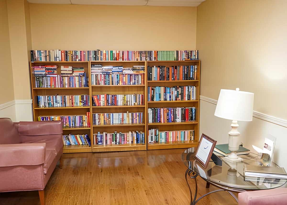 A cozy living room with a well-stocked bookshelf and comfortable seating.