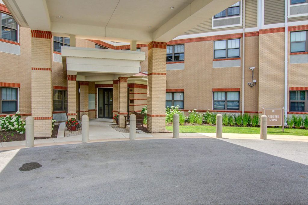 A building entrance with a covered driveway and several windows.