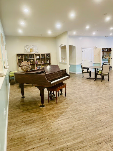 A cozy music room featuring a grand piano and seating arrangements for relaxation.