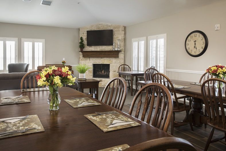 A cozy dining room with a wooden table, chairs, and a fireplace.