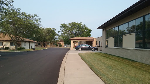 A quiet residential street with a car parked near the entrance of a building.
