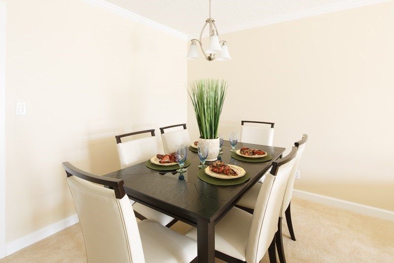 A modern dining room with a stylish table setting and decorative plant centerpiece.