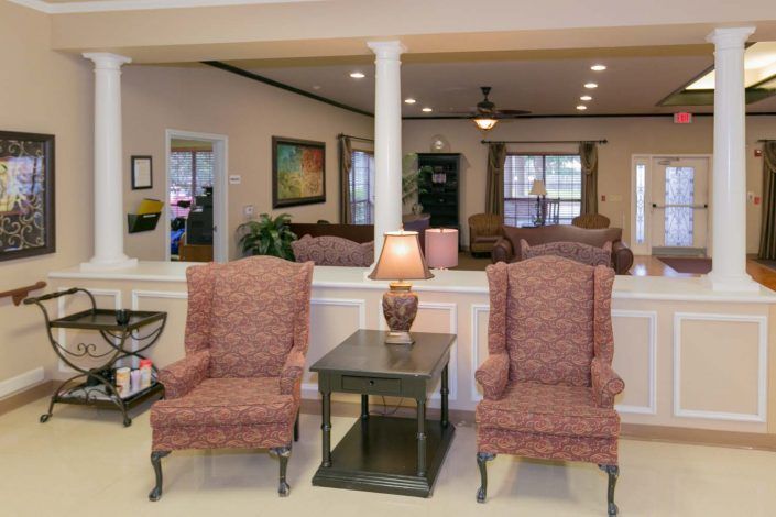 A cozy living room with two armchairs and a lamp on a side table.