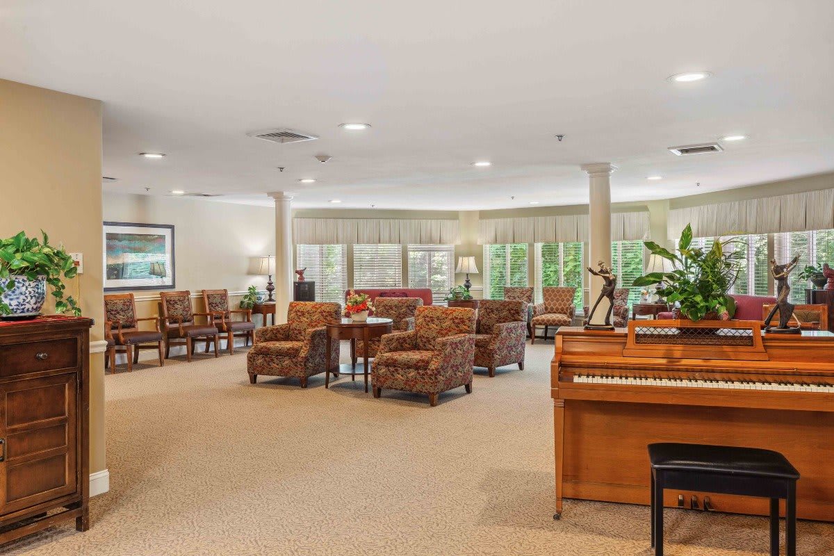 A spacious lounge area featuring comfortable seating and a piano.