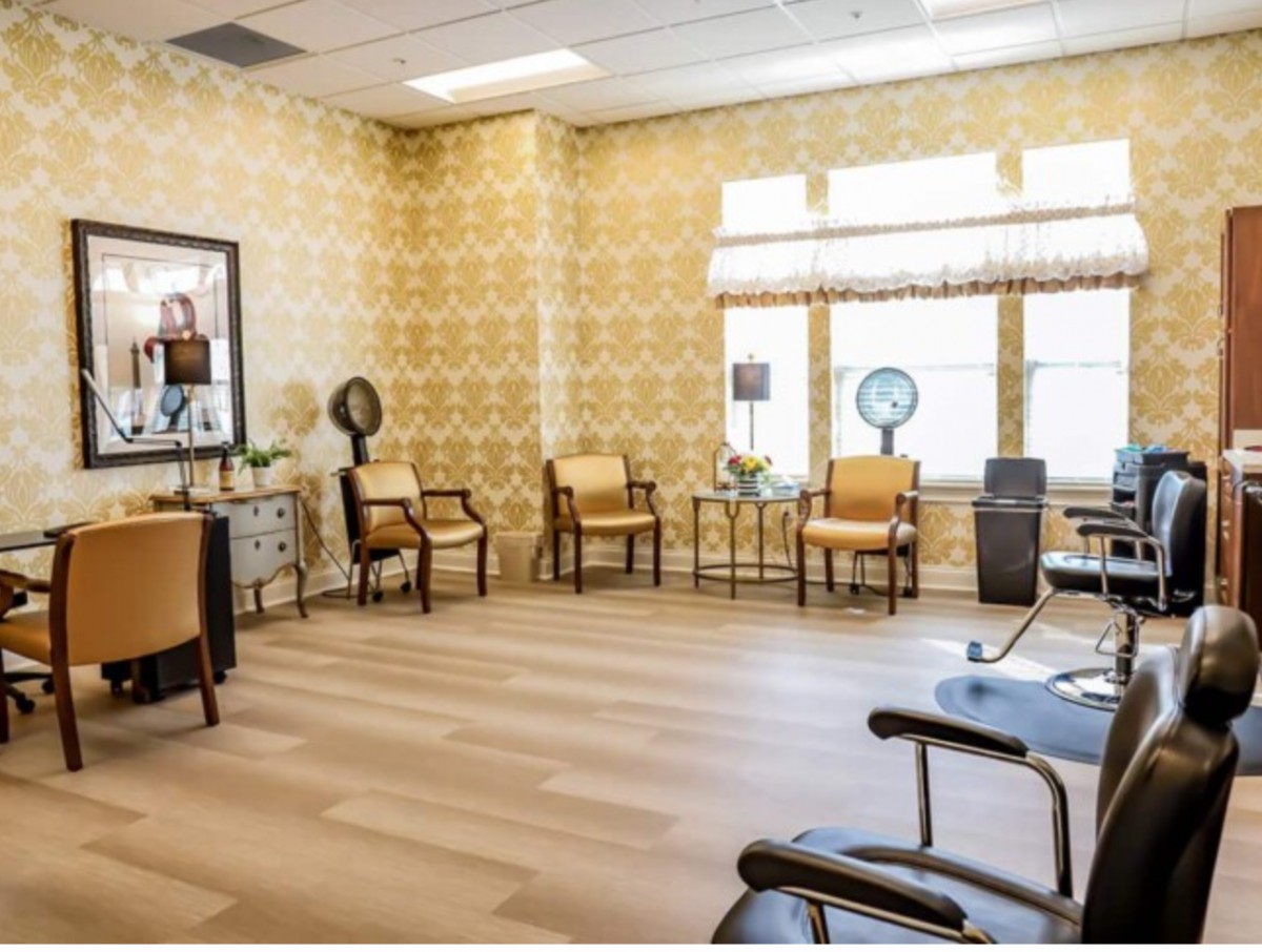 A well-lit salon interior with chairs, mirrors, and hair dryers.