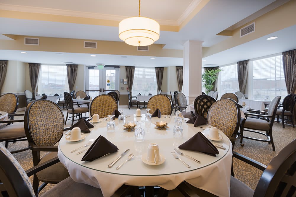 An elegantly set dining area with round tables and classic decor.