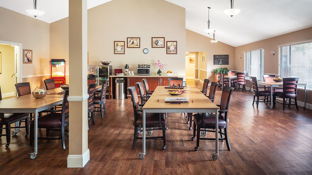 A spacious dining room with wooden floors and neatly arranged furniture.