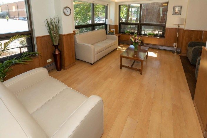 A cozy living room with sofas, a coffee table, and large windows allowing natural light to fill the space.