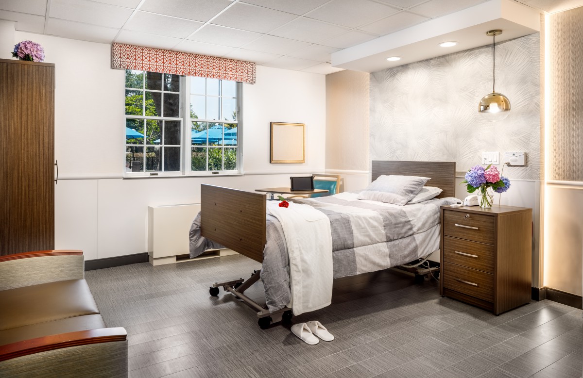 A clean and organized hospital room with a window view.