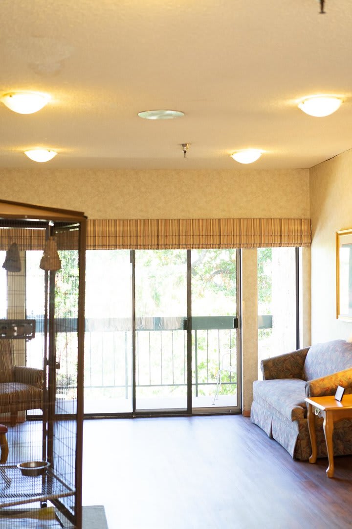 A cozy living room with a sofa and large sliding doors allowing natural light to fill the space.