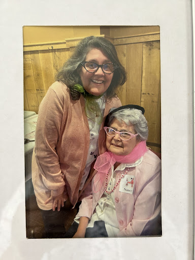 A joyful moment captured with two women sharing smiles indoors.