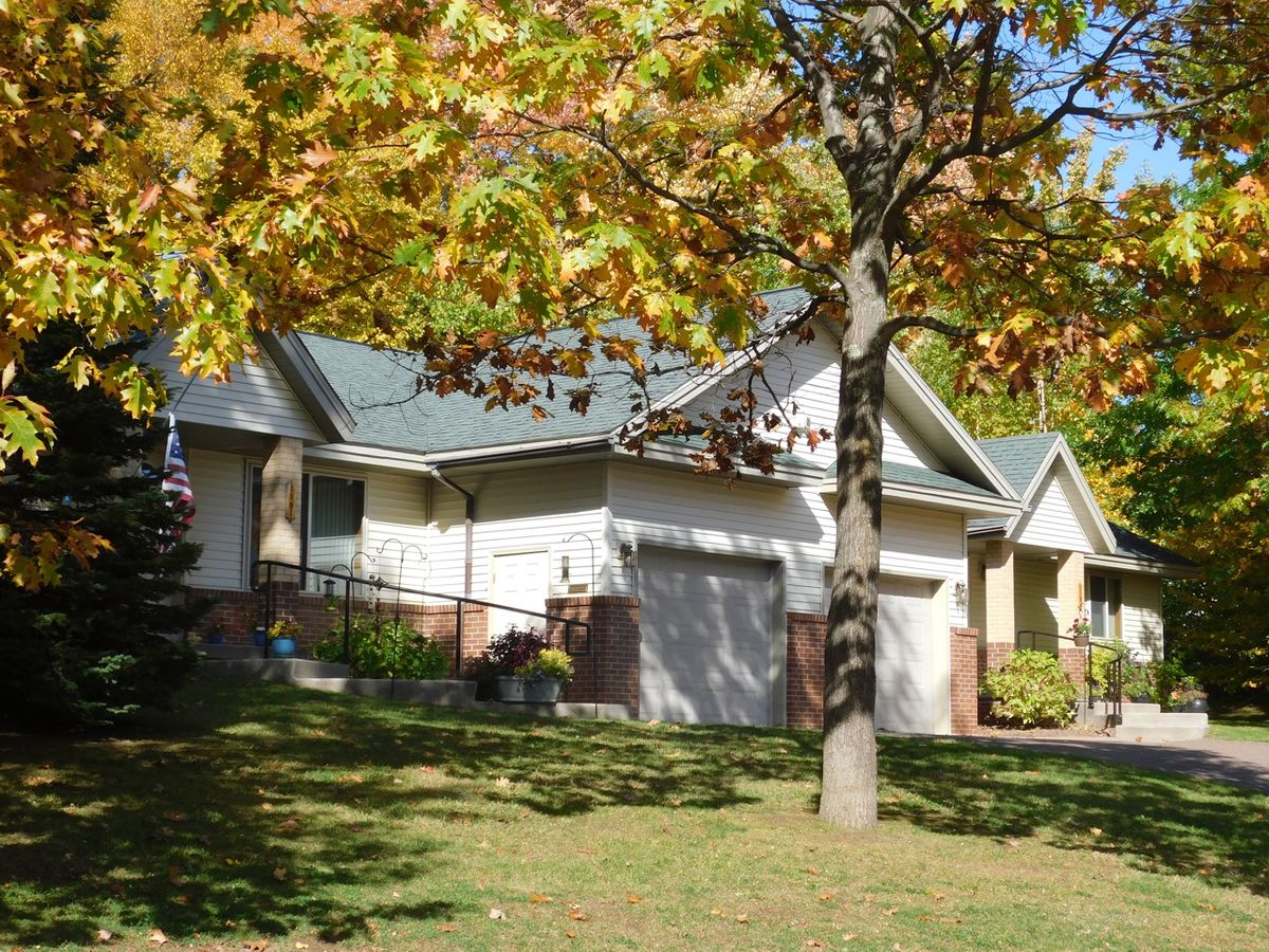 A suburban house surrounded by autumn foliage.