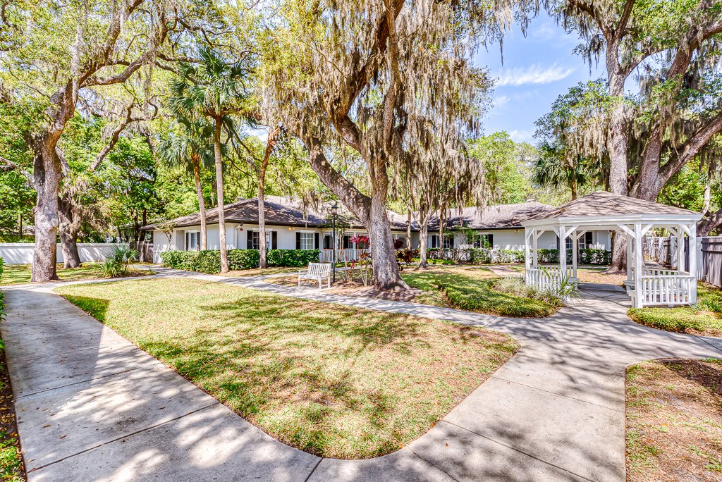 A spacious residential house surrounded by lush trees and a well-maintained yard.