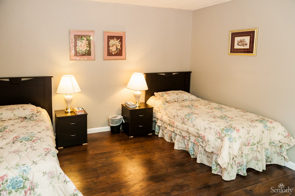 A cozy bedroom with twin beds, nightstands, and warm lighting.