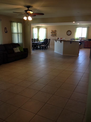 A spacious living room featuring a comfortable sofa with an adjoining dining area.