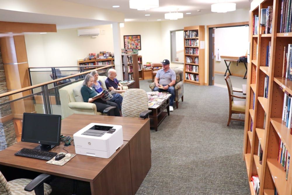 A cozy library setting with people reading and relaxing on sofas.