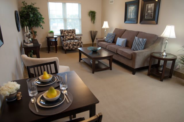 A cozy living room with a dining area, featuring comfortable seating, a coffee table, and elegant decor.