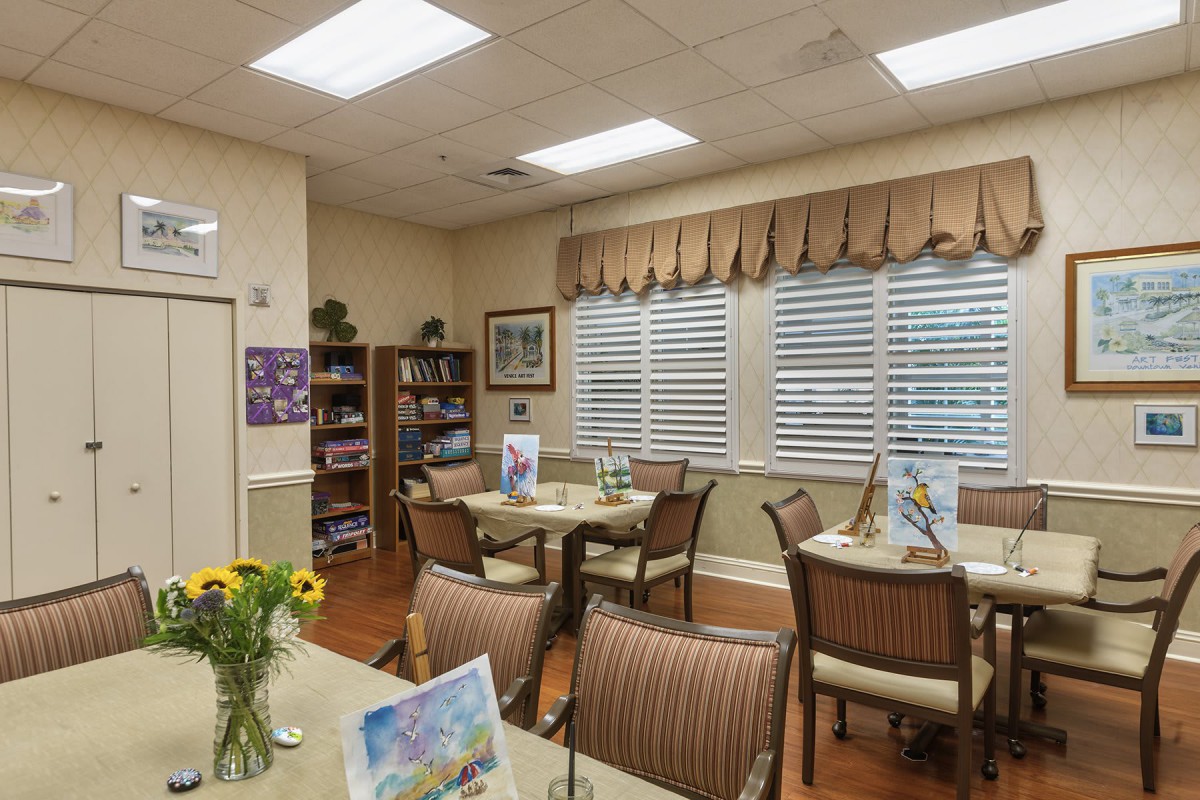 A cozy dining area with neatly arranged tables, chairs, and floral decorations.