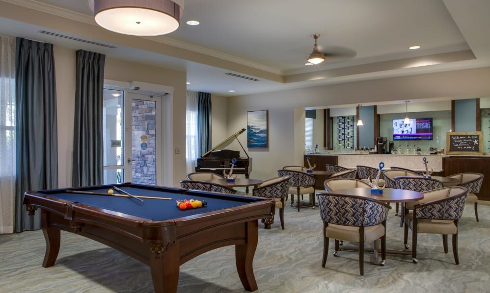 A cozy recreational area featuring a pool table, seating arrangements, and a piano.