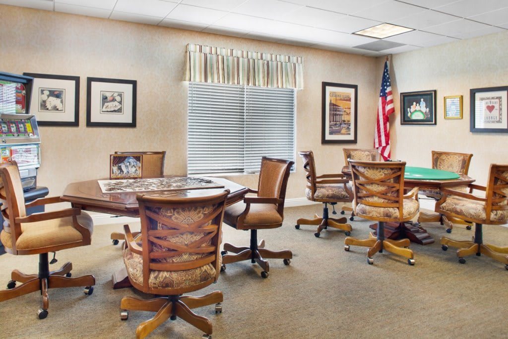 A well-furnished conference room with round tables, office chairs, and an American flag.