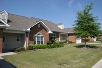 A suburban brick house with a well-maintained lawn.