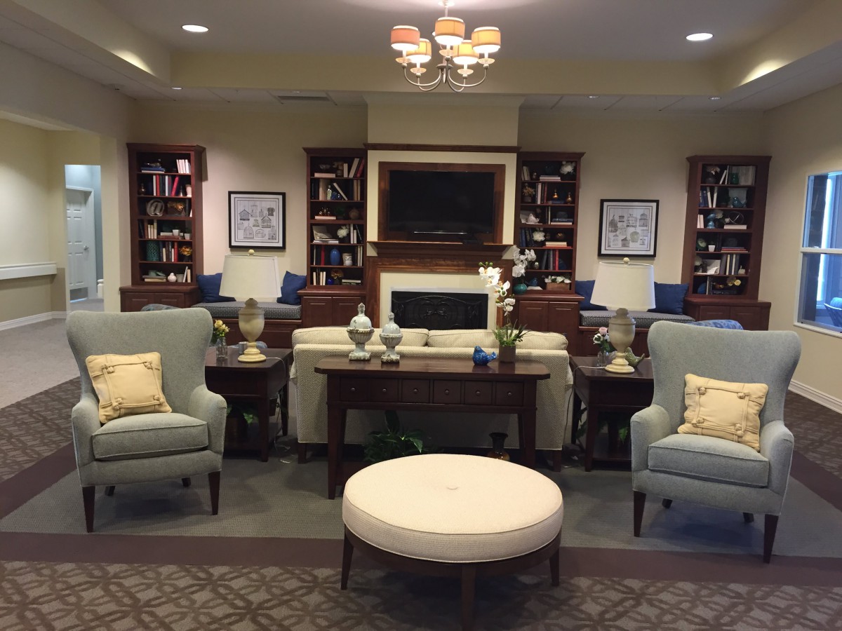 A cozy living room with comfortable seating, bookshelves, and elegant decor.