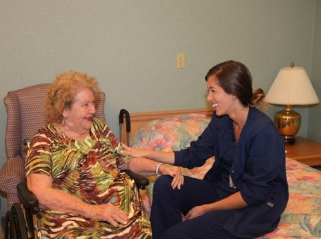 A nurse providing care to an elderly woman in a comfortable setting.