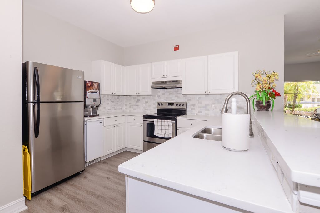 A modern kitchen with stainless steel appliances and white cabinets.