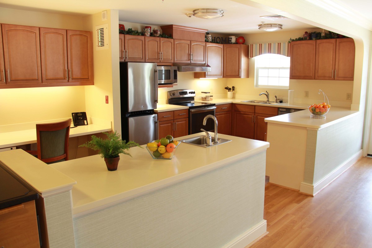 A modern kitchen with wooden cabinets, stainless steel appliances, and a central island.