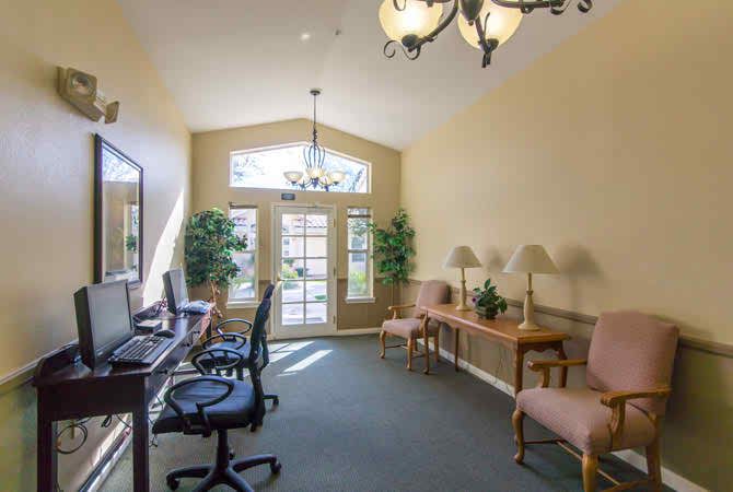 A bright office space with computers on desks and comfortable seating.
