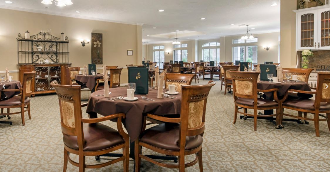 An elegant dining room with neatly arranged tables and chairs.
