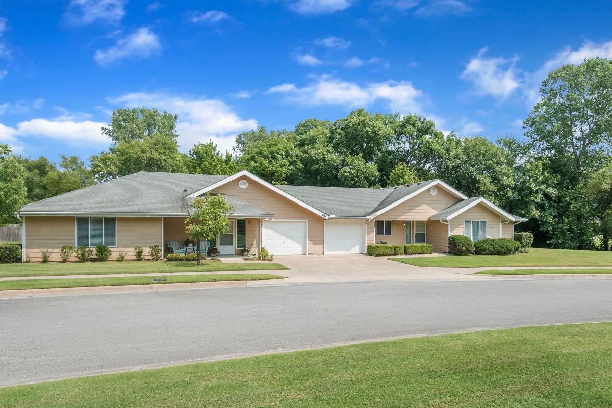 A peaceful suburban neighborhood with two houses and well-maintained lawns.