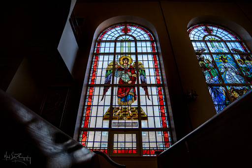 A beautifully crafted stained glass window depicting an angel in a church.