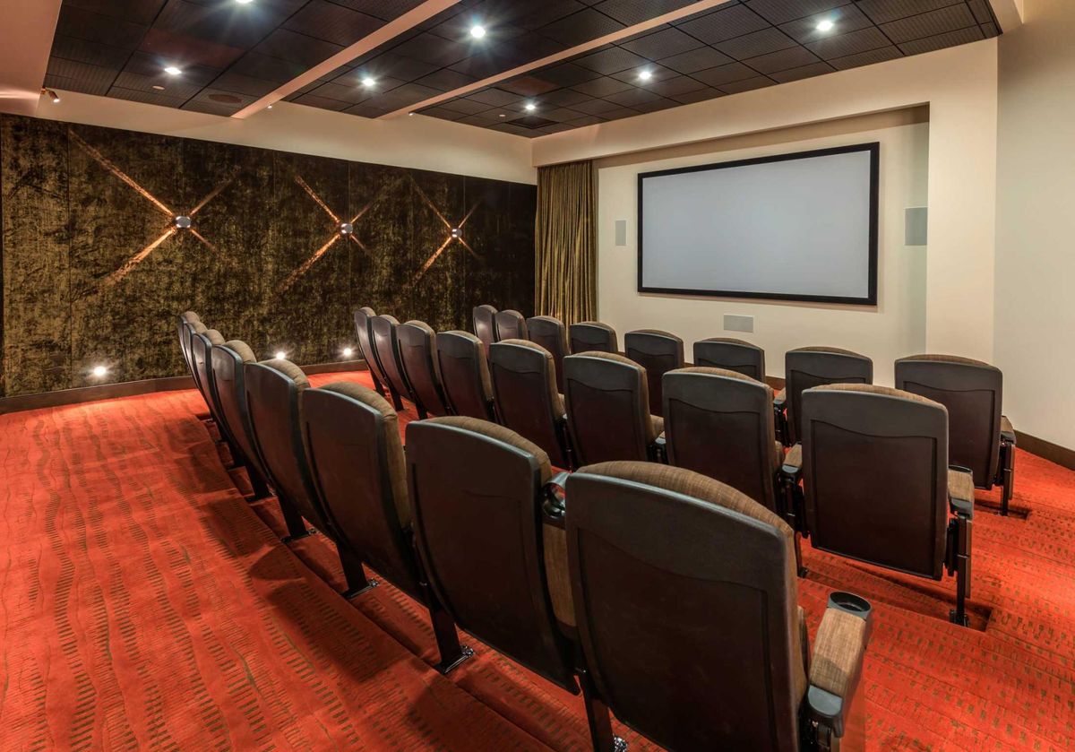 A luxurious home theater with plush seating and a large projection screen.