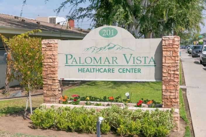 Entrance sign for Palomar Vista Healthcare Center surrounded by landscaping.