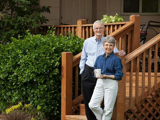 A cheerful elderly couple enjoying a moment together on their porch.