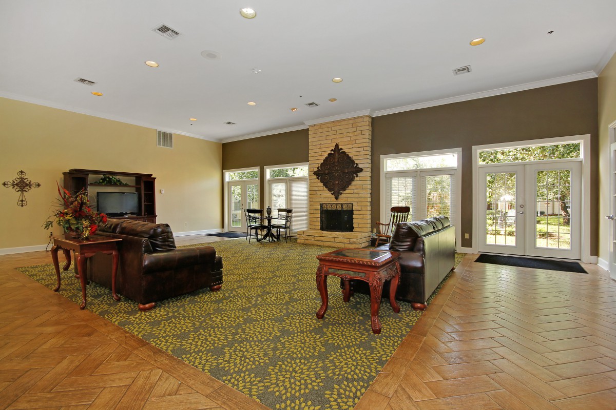 A spacious living room with comfortable seating and a centrally located fireplace.