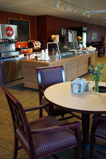 A cozy caf interior featuring a coffee station, wooden furniture, and a touch of greenery on the table.