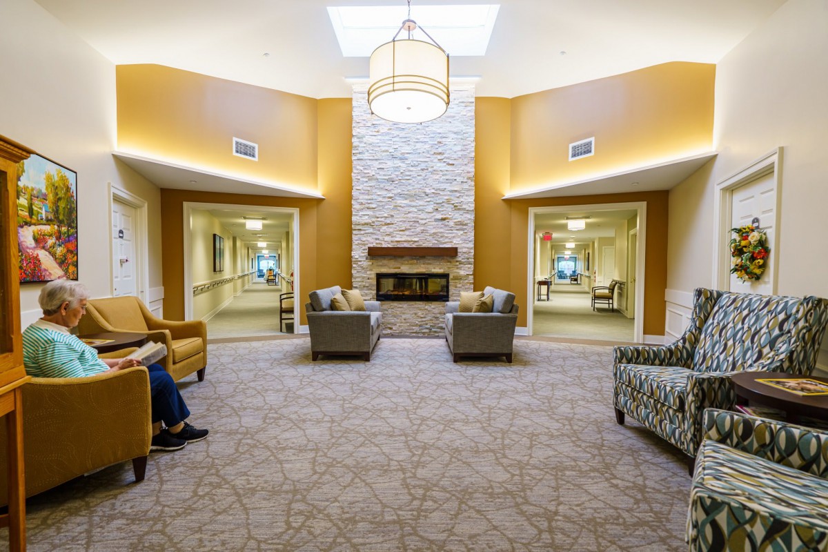 A modern lounge area featuring comfortable seating around a central fireplace.