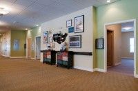 A well-lit lobby area with framed artwork and decor on the walls, featuring multiple doors.