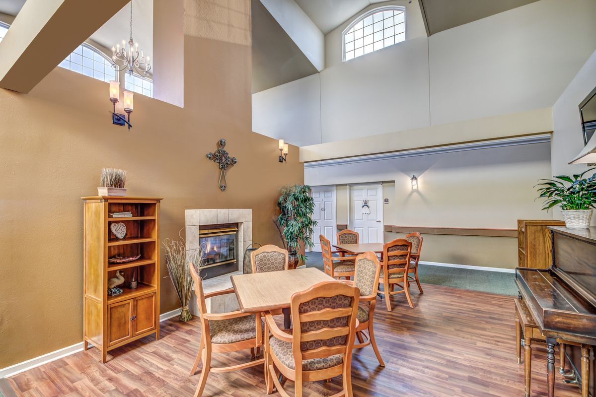A cozy living space featuring a dining area with wooden furniture, a fireplace, and elegant decor on hardwood flooring.