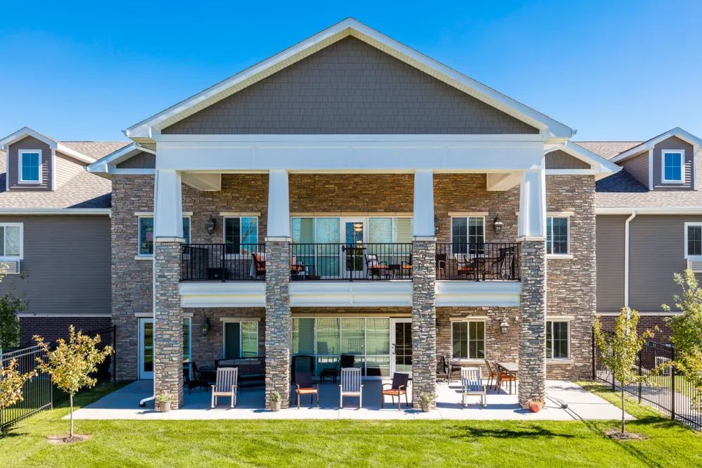 A modern residential building with a spacious lawn and balconies.