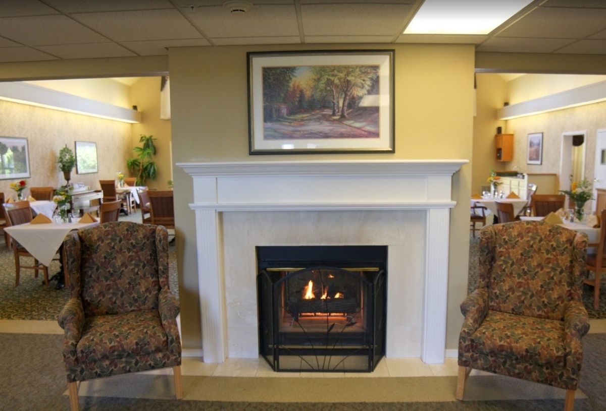 A cozy living room with a lit fireplace and comfortable seating.