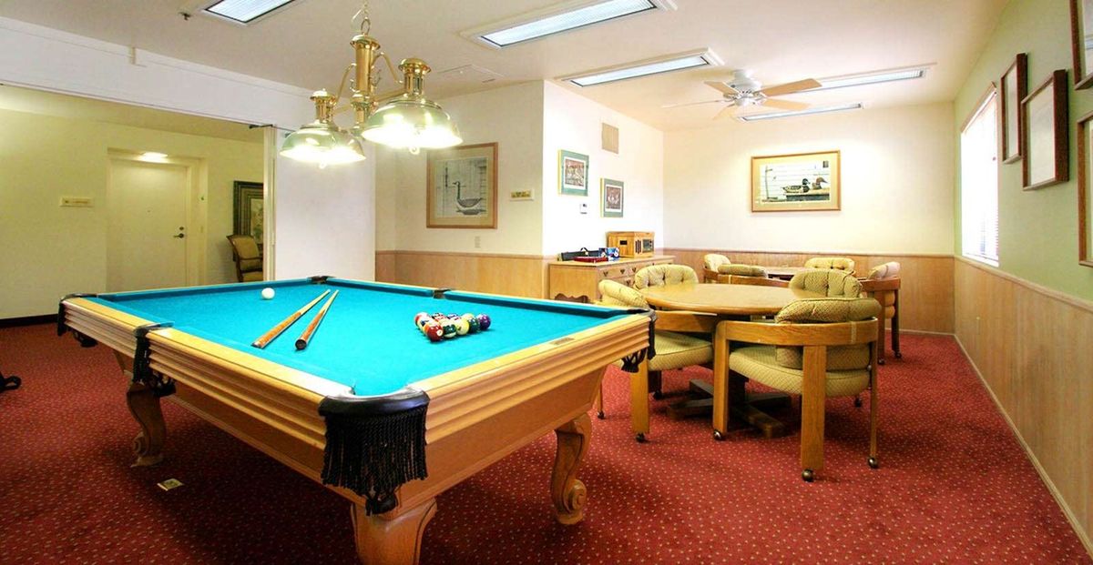 A cozy recreational room featuring a billiard table and comfortable seating.