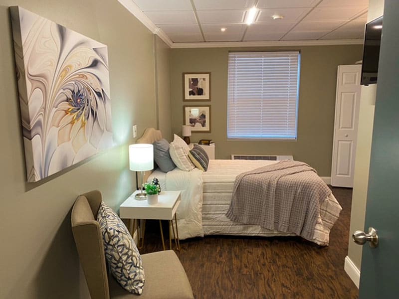 A cozy bedroom with a neatly made bed, soft lighting, and elegant decor.